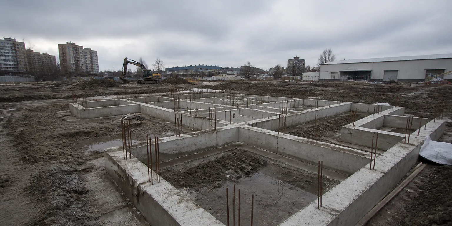 Early stage construction site with reinforced concrete foundations laid out
