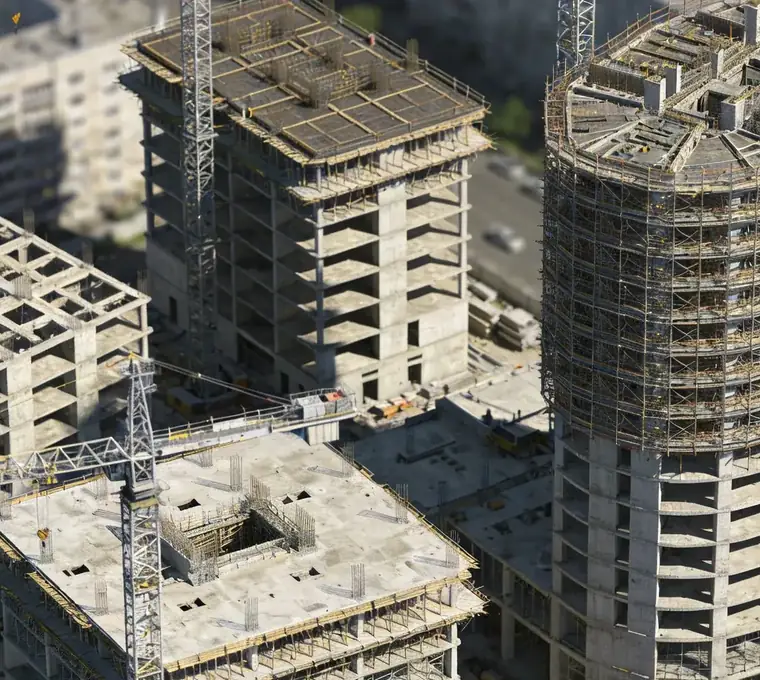 Aerial view of a large phased development with several towers and tower cranes at different stages